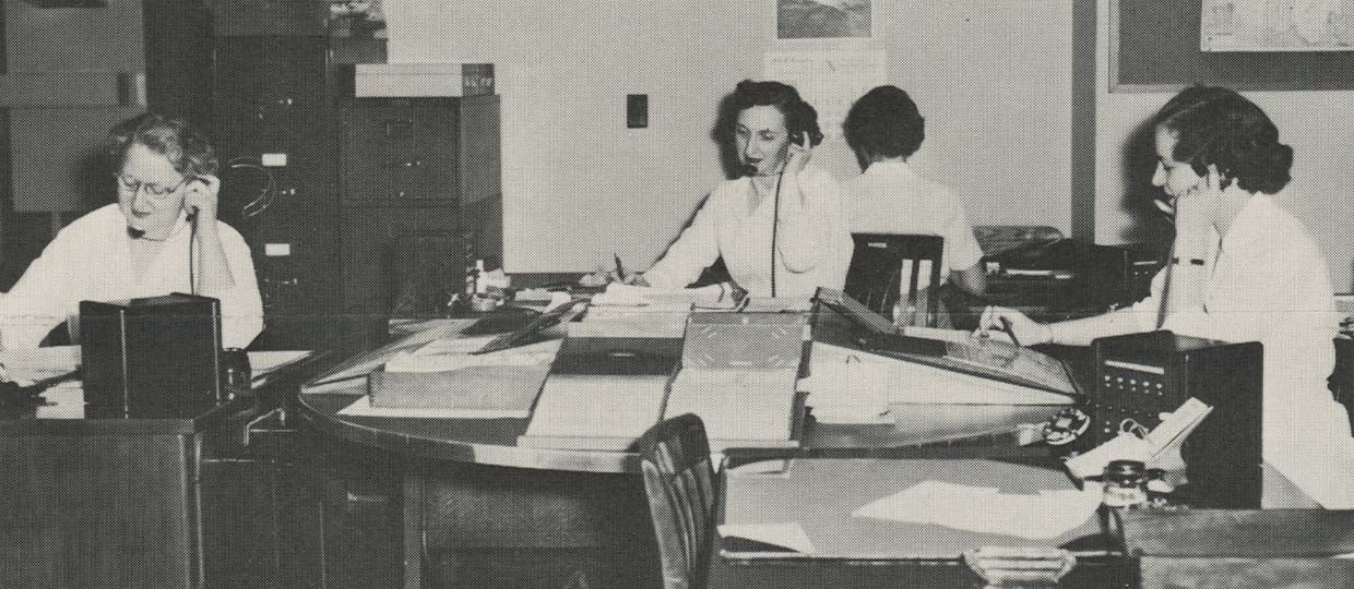 A sepia print of three woman answering phones at a call station