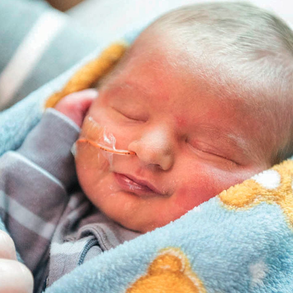 Infant boy wrapped in a blue baby's blanket