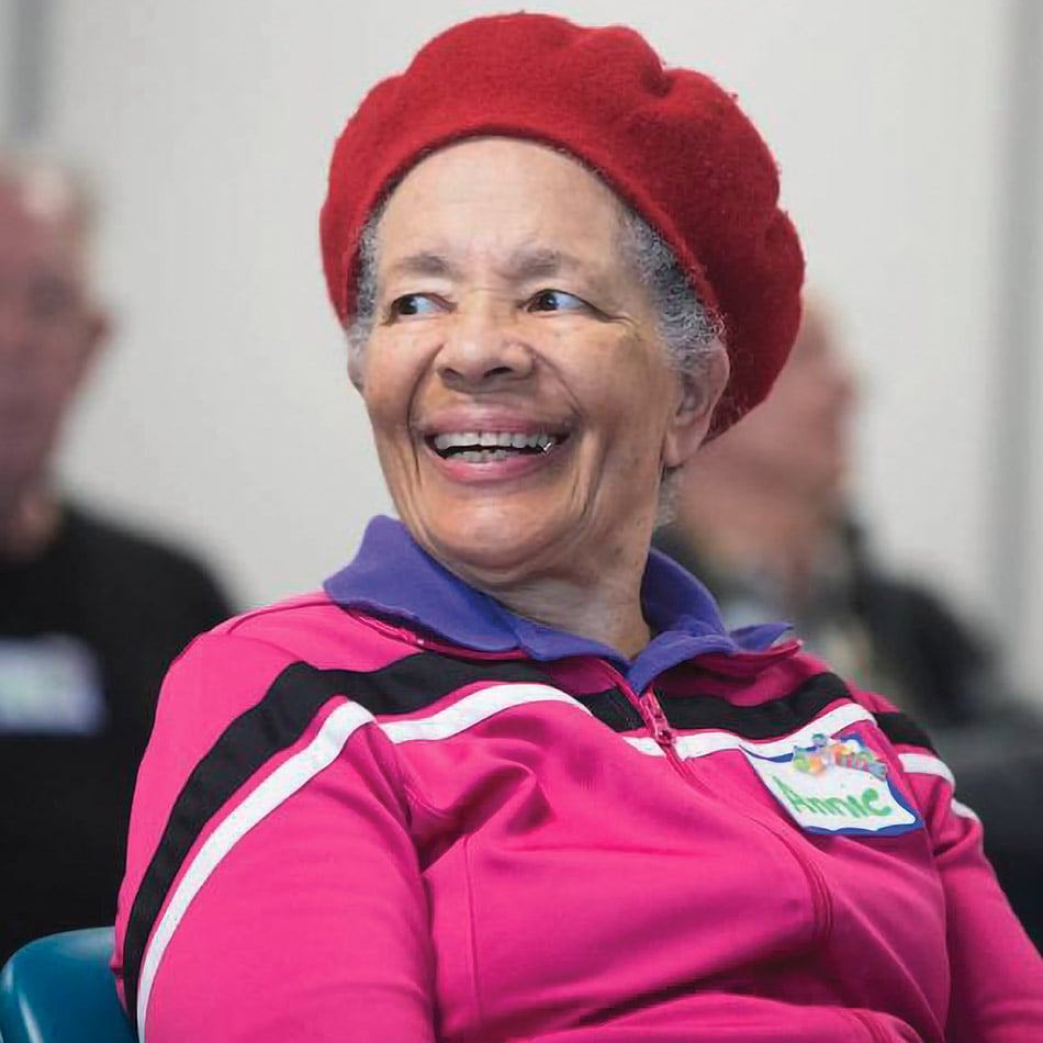 Len Hutchinson wearing a red beret and bright pink zip up jacket