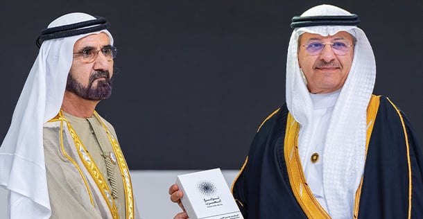 Two Arab men standing on stage holding award together