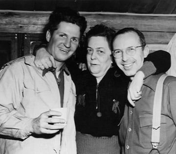 black and white image of two men and a woman with her arms around the two men