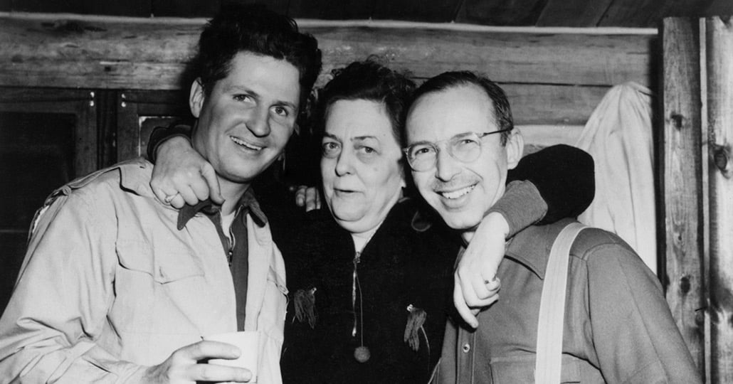 black and white image of two men and a woman with her arms around the two men