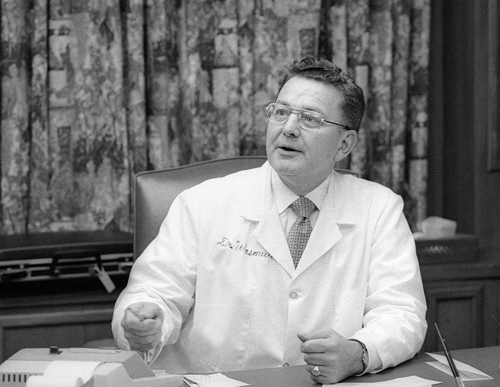 Dr. Carl Wasmuth sitting at this desk, looking out of frame