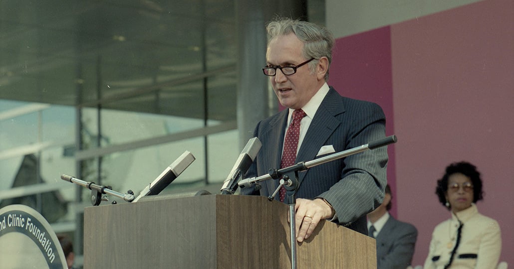 Dr. William Kiser standing behind a podium, speaking into a microphone.