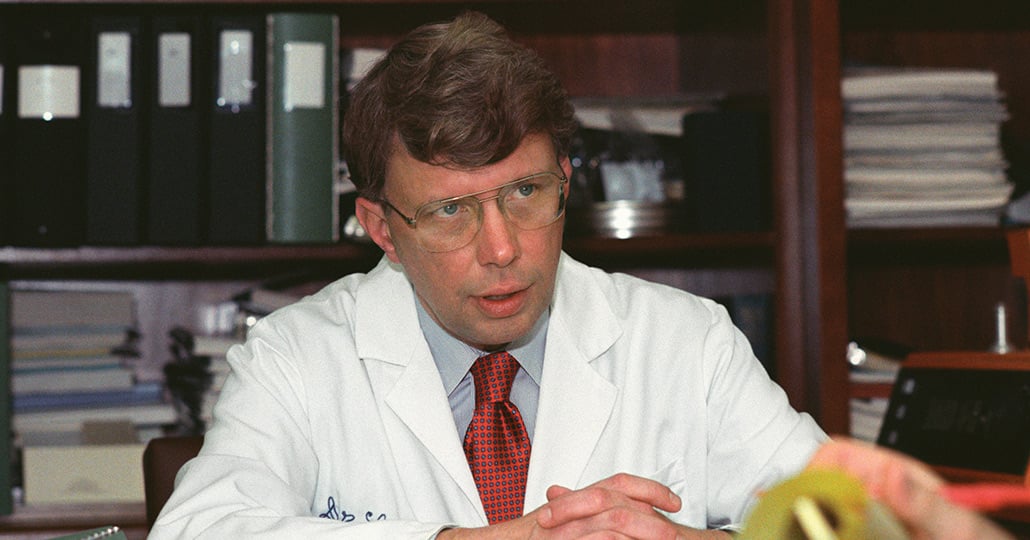 Dr. Floyd Loop sitting behind his desk looking at someone out of frame.