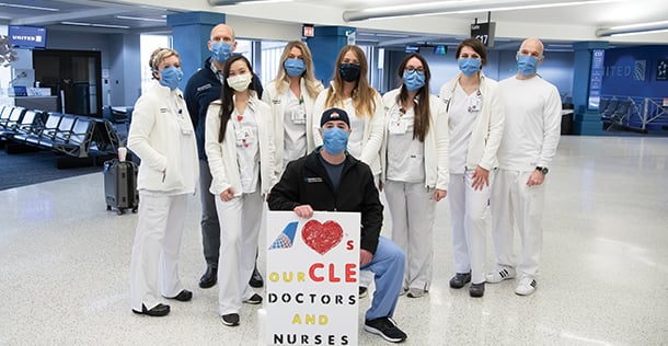 group of medical professionals posing with a poster in the Cleveland airport