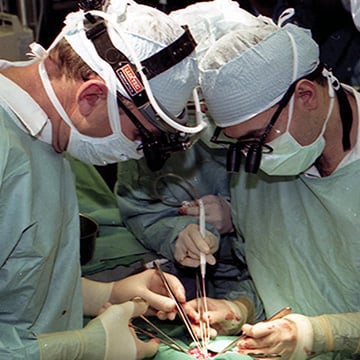 Three surgeons perform surgery