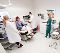 A panoramic image of a hospital room with medical works and a patient inside