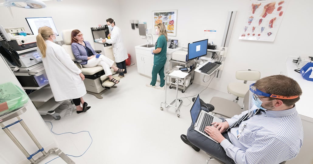 A panoramic image of a hospital room with medical works and a patient inside