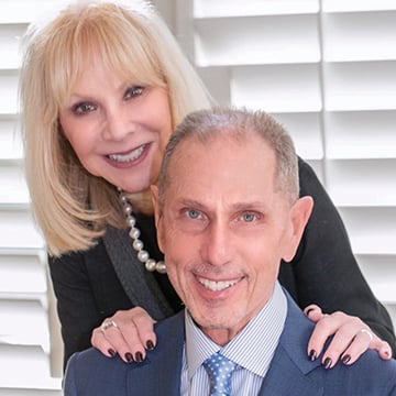 Bob (right) and Susan (left) Hurwitz, posing for a photo with Susan's hands on Bob's shoulders