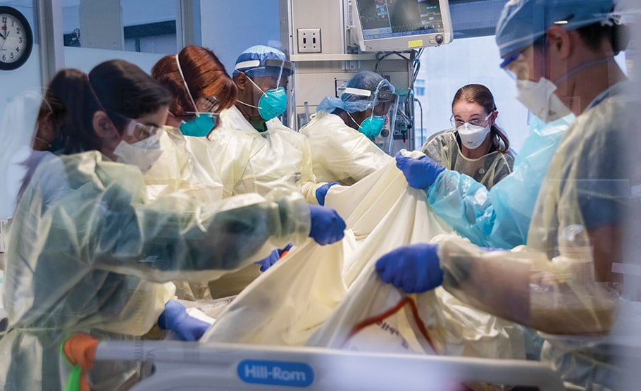 A group of doctors and nurses helping a patient in the ICU