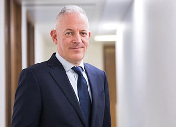 Richard Cohen wearing a suit and smiling at the camera