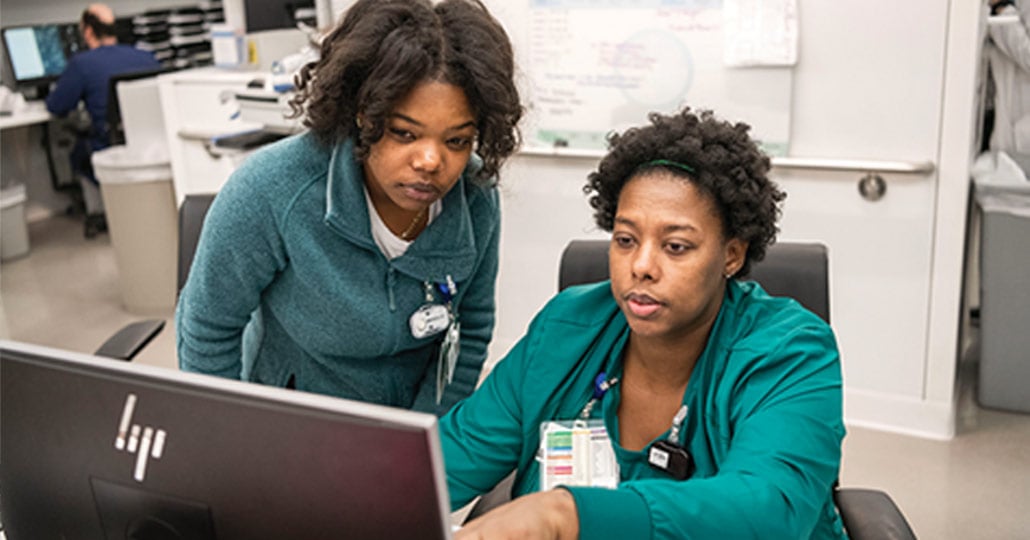 two female doctors looking at a computer monitor