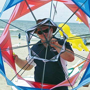 Man holding a kite into the camera