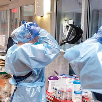 Doctors putting on protect gear in a hospital