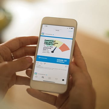 Hands holding a smartphone with a meter on the screen.