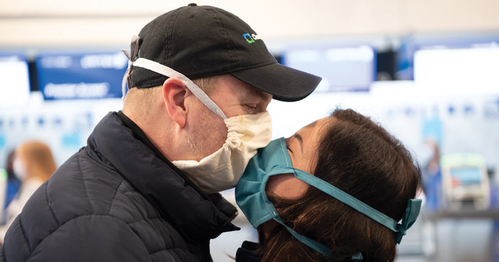 Masked couple kissing