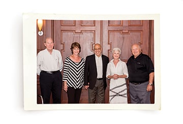 A Polaroid photo of a family standing in front of a door