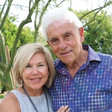 Senior couple outside, woman wearing white tank and man wearing patterned purple shirt