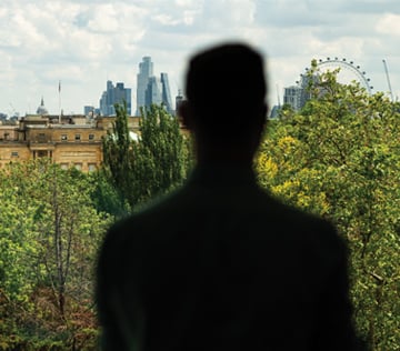 Silhouette of man in front of panorama view of London