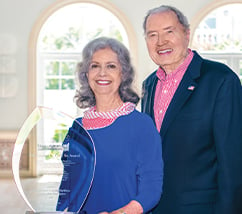 Senior couple standing next to award